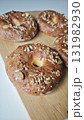 Freshly baked bagels topped with mixed seeds on a wooden board 131982930