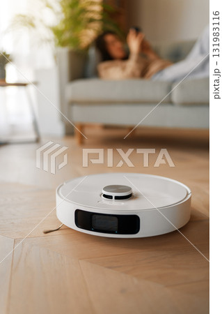 White robotic vacuum cleaner on wooden floor White robotic vacuum cleaner on wooden floor 131983116