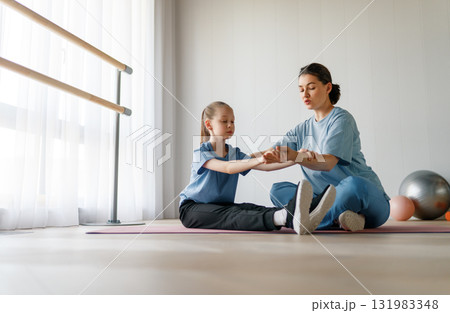 girl doing exercises under doctor's supervision girl doing exercises under doctor's supervision 131983348
