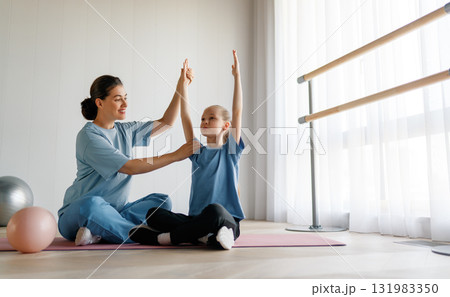 girl doing exercises under doctor's supervision 131983350