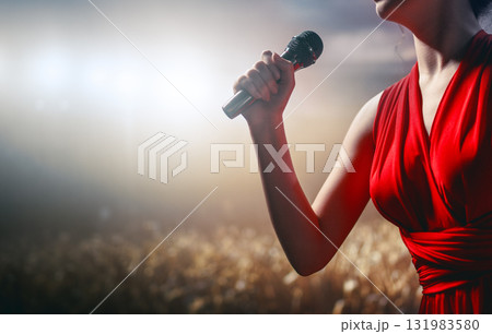 A singer on stage with a microphone 131983580