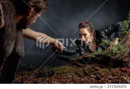 The young man rescues the girl by holding out his hand to her. 131984003