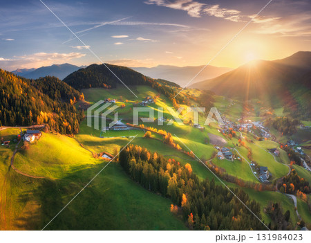 Aerial view of green alpine valley at sunset with villages Aerial view of green alpine valley at sunset with villages 131984023