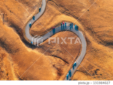 Aerial view of winding road in mountain pass at sunset in autumn 131984027