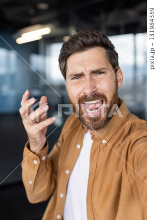 Bearded man experiencing anger and frustration, shouting and gesturing during a disagreement or conflict, capturing his distressed expression and intense emotions in an office environment Bearded man experiencing anger and frustration, shouting and gesturing during a disagreement or conflict, capturing his distressed expression and intense emotions in an office environment 131984389