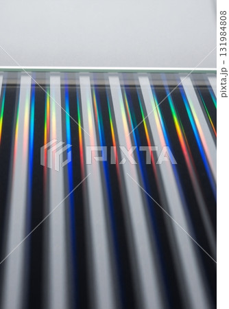 Abstract macro shot of a striped glass surface reflecting colored light. Modern geometric pattern with a rainbow spectrum and copy space Abstract macro shot of a striped glass surface reflecting colored light. Modern geometric pattern with a rainbow spectrum and copy space 131984808