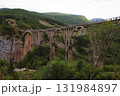 A wide-angle, iconic view of the Tara Bridge, a massive concrete arch bridge spanning the deep Tara River Canyon in Montenegro. 131984897
