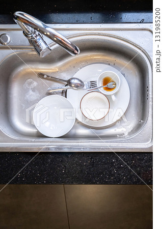 Dirty dishes in kitchen sink. Unwashed plates, bowls and cutlery 131985200