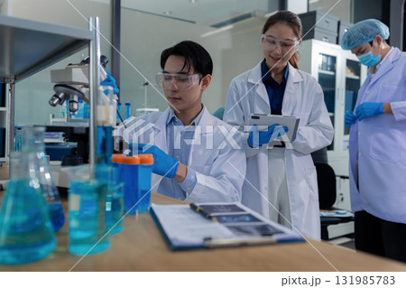 Scientist mixing chemical liquids in the chemistry lab. Researcher working in the chemical laboratory. 131985783