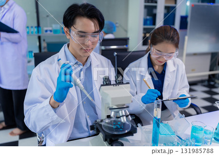 Scientist mixing chemical liquids in the chemistry lab. Researcher working in the chemical laboratory. 131985788
