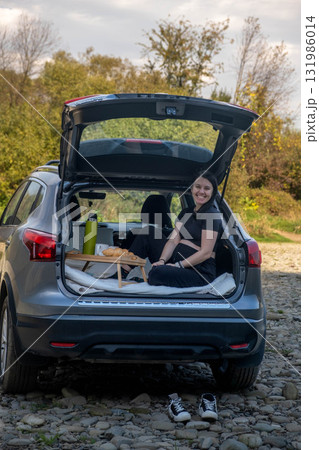 Woman Relaxing in Car Trunk in Nature Woman Relaxing in Car Trunk in Nature 131986014