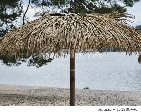 A Beautiful Tropical Beach Umbrella is Positioned Perfectly by the Calm Water of the Ocean 131986446
