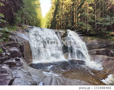 A breathtakingly serene waterfall nestled within a lush green forest awaits your discovery 131986468