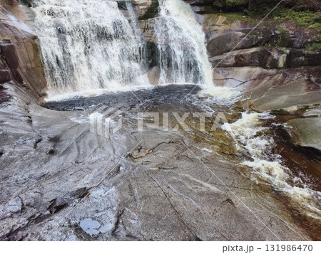 Breathtaking Waterfall Cascading Gracefully Over the Rocky Terrain of Natures Splendor 131986470