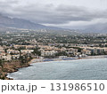 A breathtaking, scenic coastal view showcasing beautiful mountains beneath a cloudy sky 131986510