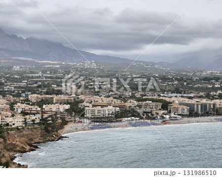 A breathtaking, scenic coastal view showcasing beautiful mountains beneath a cloudy sky A breathtaking, scenic coastal view showcasing beautiful mountains beneath a cloudy sky 131986510