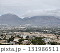 A breathtaking scenic view of majestic mountains and a charming town on a cloudy day 131986511