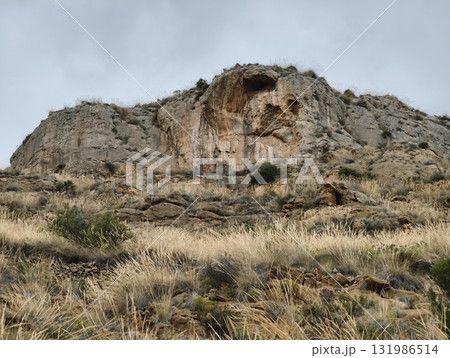 A Majestic Rocky Outcrop Rising High and Proud Beneath a Dramatic and Cloudy Sky Above 131986514