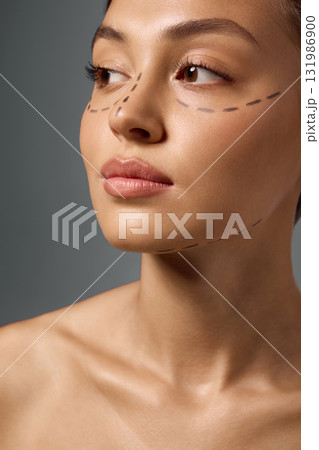 Portrait of woman with face markings looking aside expressing confidence and balance Portrait of woman with face markings looking aside expressing confidence and balance 131986900