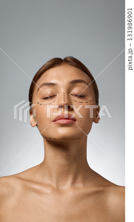 Woman with face markings and closed eyes showing calm trust before cosmetic procedure Woman with face markings and closed eyes showing calm trust before cosmetic procedure 131986901