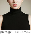 Young woman wearing a black turtleneck top against a neutral 131987567