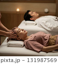 Couple receiving head massage in a spa, calm mood, soft lighting 131987569