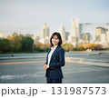 Young woman in business suit standing in city park, calm mood 131987573