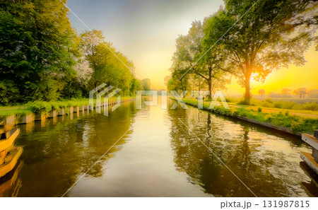 A Serene River Glowing at Sunrise Surrounded by Lush Greenery and Reflective Waters A Serene River Glowing at Sunrise Surrounded by Lush Greenery and Reflective Waters 131987815