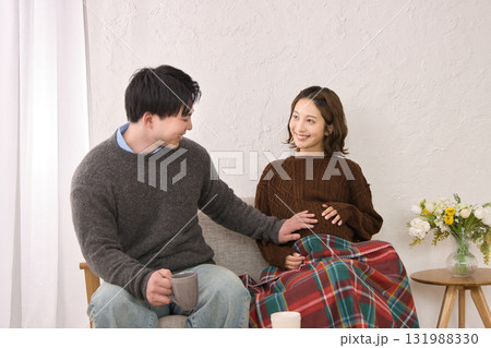 ソファに座ってくつろぐ若い夫婦　妊婦さん 131988330
