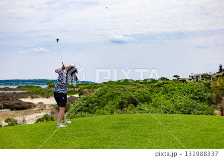 南国の青い海のリゾートのゴルフ場・海越えホールでドライバーを打つゴルファー（沖縄県宮古島市） 131988337