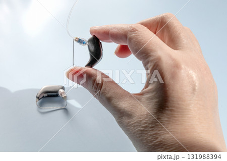 Female hand holding modern hearing aid 131988394