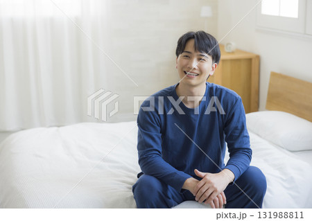 ベッドで伸びをする男性　  131988811
