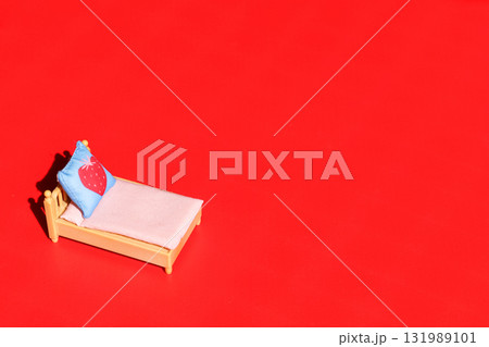 Decorated bed with pillow on red background. Decorated bed with pillow on red background. 131989101