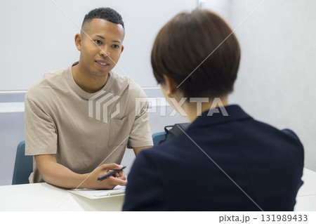 外国人の男性に説明をする女性　　 131989433