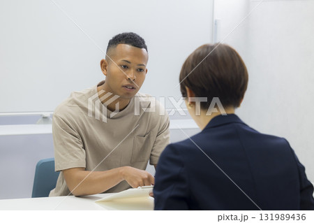外国人の男性に説明をする女性 外国人の男性に説明をする女性 131989436