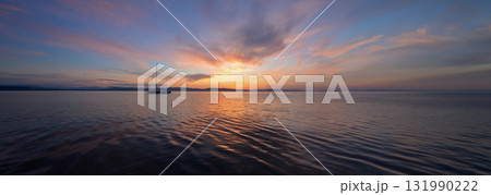 Panoramic view of a sailboat at anchor on Lake Champlain at sunset 131990222