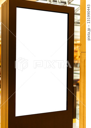 A blank digital display stand is positioned in a contemporary interior. The space is filled with warm lighting, creating an inviting atmosphere 131990443