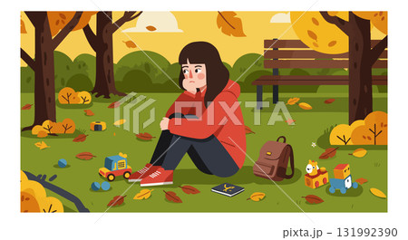 Sad girl sitting alone in autumn park with scattered toys and fallen leaves 131992390