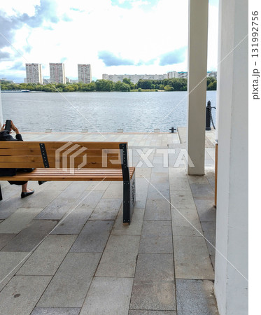Bench on waterfront river view person sitting by the water 131992756