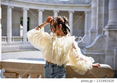 Elegant woman enjoying sunlight in ruffled blouse in Paris Elegant woman enjoying sunlight in ruffled blouse in Paris 131992826