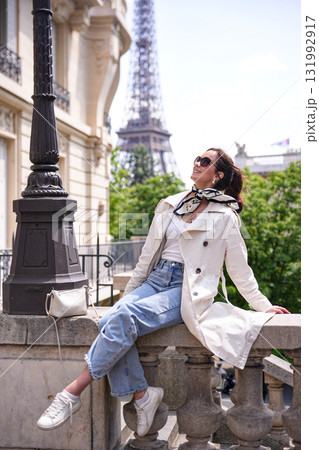 Joyful woman relaxing near Eiffel Tower in Paris 131992917