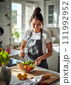 明るいキッチンで料理する女性 131992952
