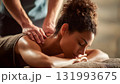 A female therapist provides a calming back massage to a woman client, emphasizing self-care, luxury, and professional spa wellness treatment. AI Generated 131993675