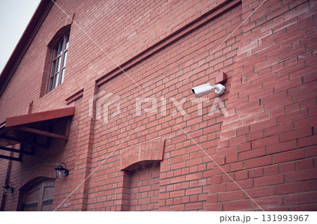 Security camera on the wall of a brick building Security camera on the wall of a brick building 131993967