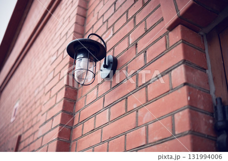 Street lamp on the wall of a brick building Street lamp on the wall of a brick building 131994006