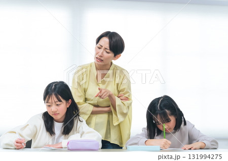 勉強する二人の女の子と厳しく指導する女性 勉強する二人の女の子と厳しく指導する女性 131994275