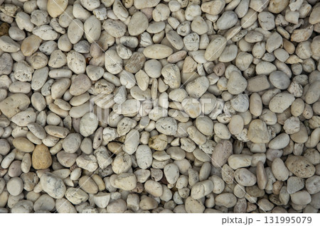 Smooth river stones bathed in warm sunlight, creating a naturally textured, peaceful background perfect for design projects and tranquil visuals. Smooth river stones bathed in warm sunlight, creating a naturally textured, peaceful background perfect for design projects and tranquil visuals. 131995079