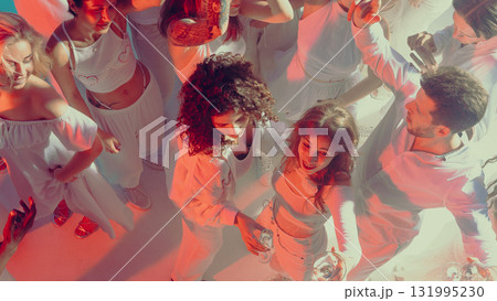 Women and men dancing closely with energy at festive party in neon lighted club 131995230