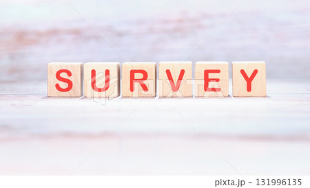 Wooden blocks, each displaying a red letter, spell out SURVEY. The blocks sit neatly aligned on a textured white surface, inviting participation and input Wooden blocks, each displaying a red letter, spell out SURVEY. The blocks sit neatly aligned on a textured white surface, inviting participation and input 131996135