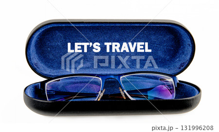 Eyeglasses rest inside an open, lined case. The case has LET IS TRAVEL printed inside. It evokes the anticipation of seeing new sights on an upcoming trip 131996208